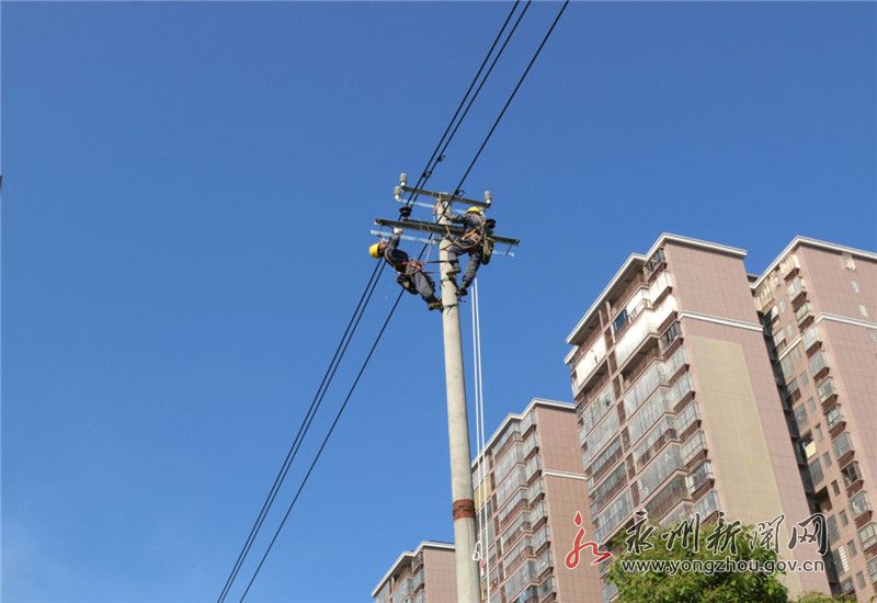 在宁远县舜帝南路10千伏逍仪i线,ii线施工现场,电力工人在安装横档,架