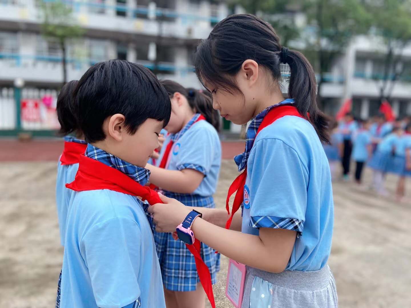 老队员为新队员佩戴红领巾